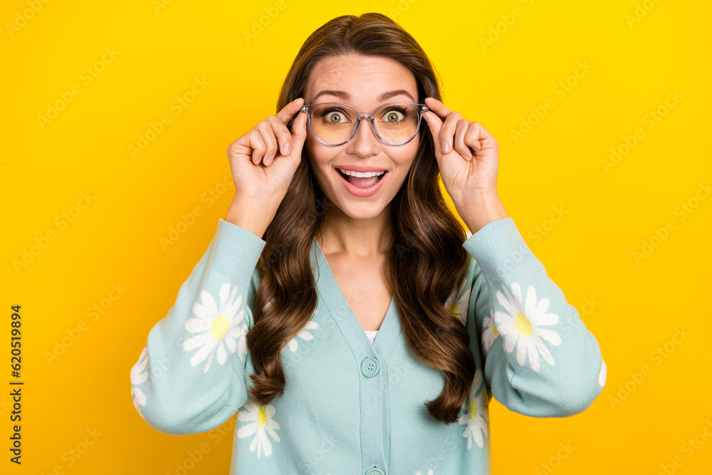 Portrait of young surprised astonished funny girl hold her eyeglasses surprised good vision stylish spectacles isolated on yellow color background Portrait of young surprised astonished funny girl hold her eyeglasses surprised good vision stylish spectacles isolated on yellow color background