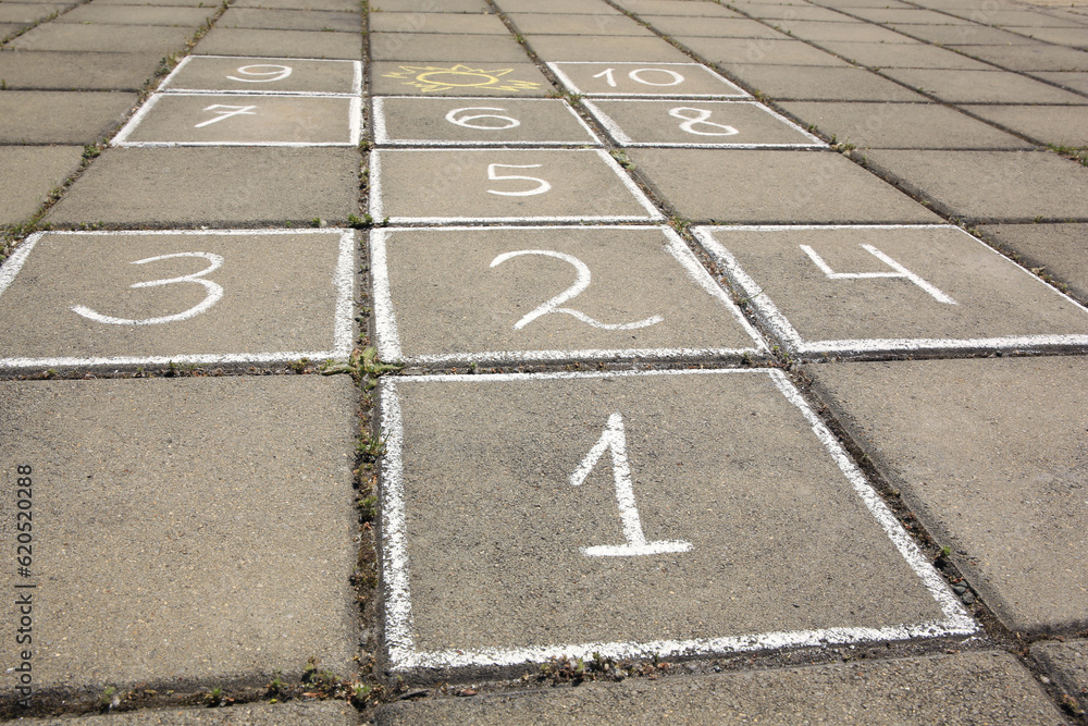 Fototapeta premium Hopscotch drawn with white chalk on street tiles outdoors