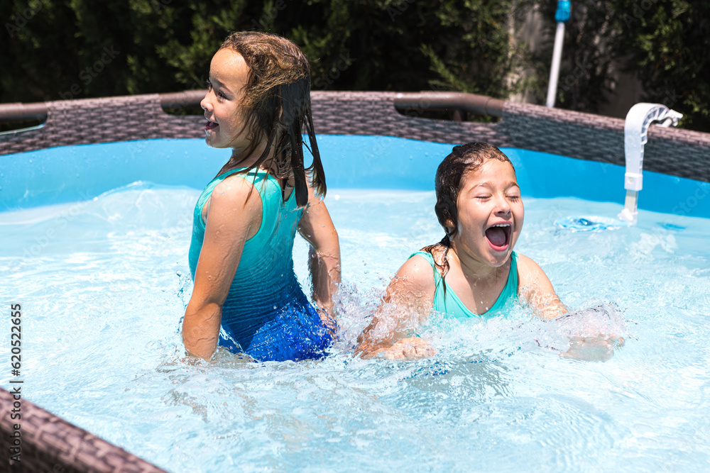 Two girls, in a pool, enjoying themselves in the water. Pool, swimming, swimsuit, children, summer, relax, vacation, resort and travel concept. Two girls, in a pool, enjoying themselves in the water. Pool, swimming, swimsuit, children, summer, relax, vacation, resort and travel concept.