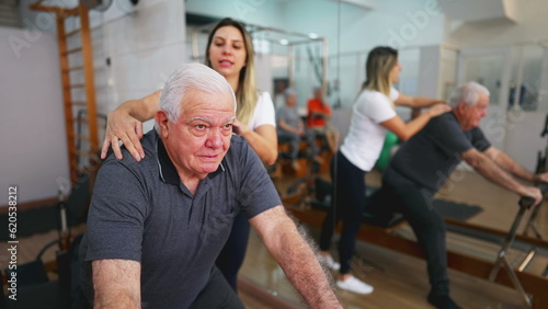 Senior Man Exercising in Guided Workout, Pilates Studio Session with Female Coach, elderly person using machine to stretch, taking care of spine health