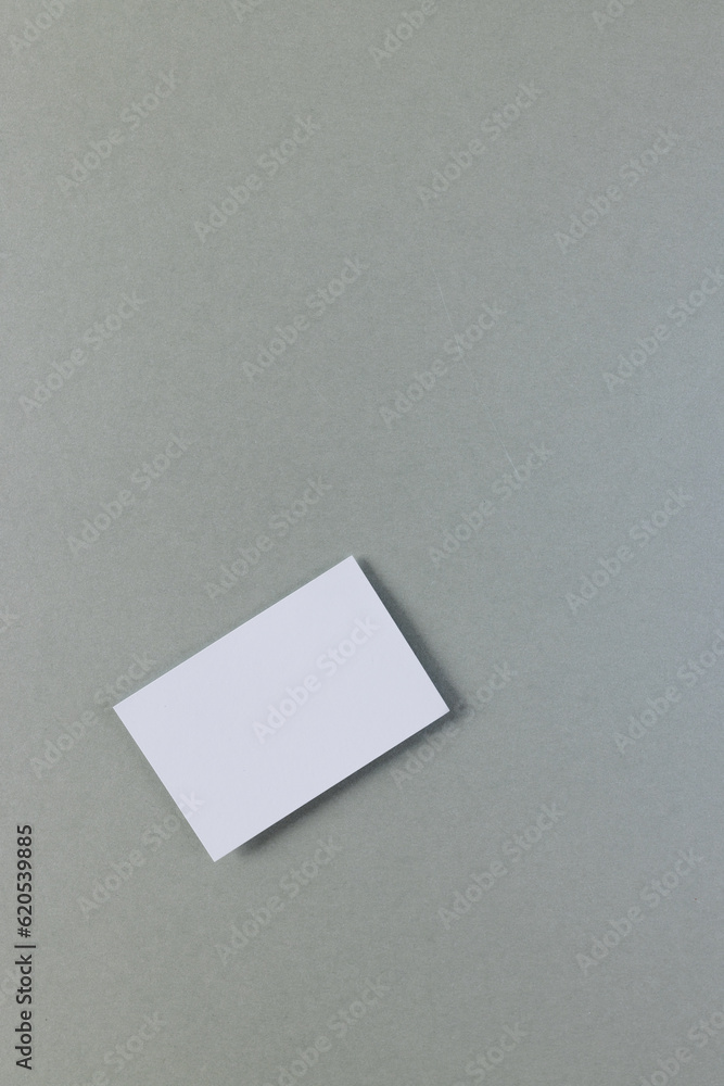 Vertical image of white business card with copy space on grey background Vertical image of white business card with copy space on grey background