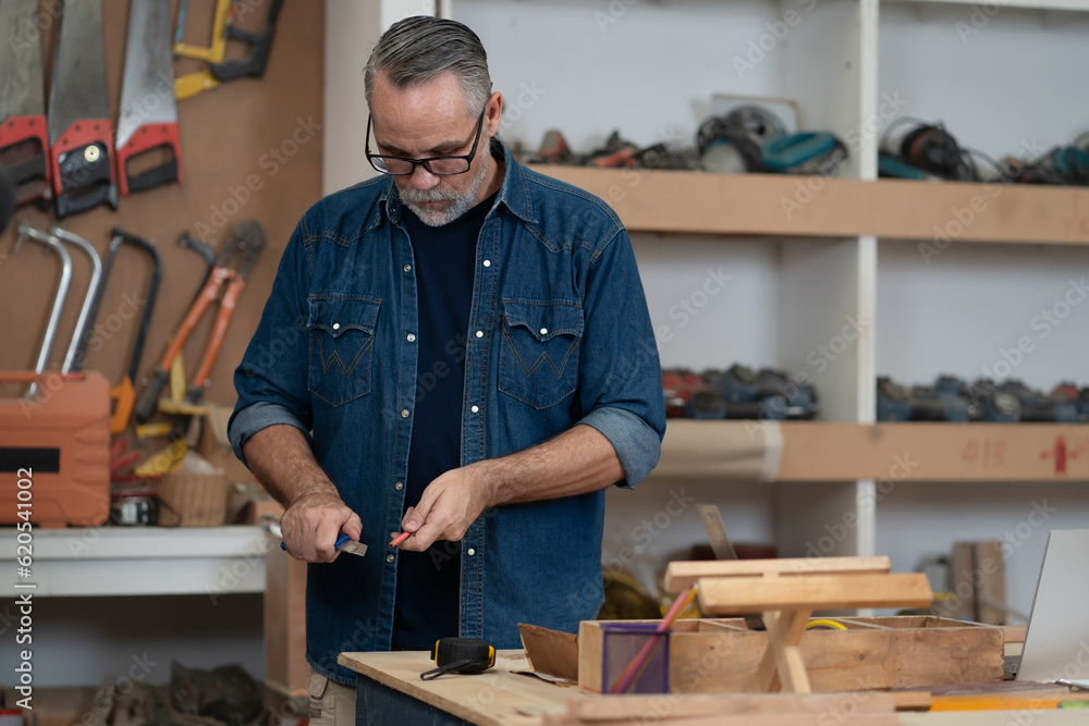 Bearded man carpenter working with skill in carpentry workshop. Professional joiner works with tools in woodworking. Portrait of mature woodworker making or repairing furniture. Craftmanship industry Bearded man carpenter working with skill in carpentry workshop. Professional joiner works with tools in woodworking. Portrait of mature woodworker making or repairing furniture. Craftmanship industry
