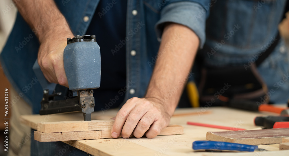 Male carpenter working with skill in carpentry workshop. Professional joiner works with tools in woodworking. closeup of mature woodworker making or repairing furniture. Craftmanship industry Male carpenter working with skill in carpentry workshop. Professional joiner works with tools in woodworking. closeup of mature woodworker making or repairing furniture. Craftmanship industry