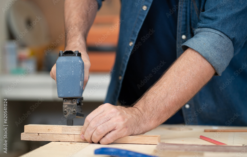 Male carpenter working with skill in carpentry workshop. Professional joiner works with tools in woodworking. Closeup mature woodworker making or repairing furniture. Craftmanship industry Male carpenter working with skill in carpentry workshop. Professional joiner works with tools in woodworking. Closeup mature woodworker making or repairing furniture. Craftmanship industry