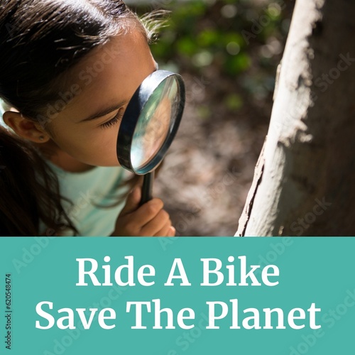 Composition of ride a bike save the planet text over biracial girl with magnifying glass by tree