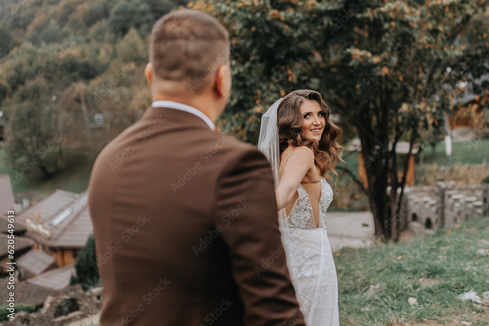 The bride in a wedding dress leads the groom on a wedding journey The bride in a wedding dress leads the groom on a wedding journey