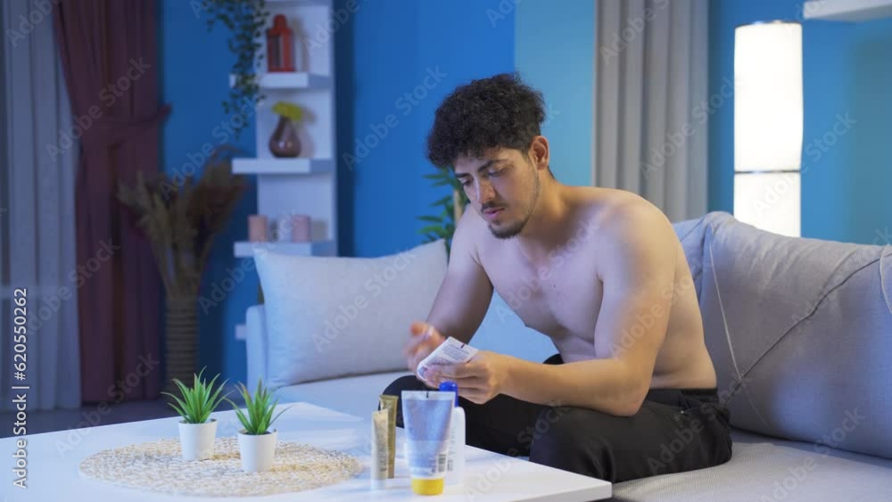 Young man applying treatment cream to his face and skin. Young man applying treatment cream to his face and skin.