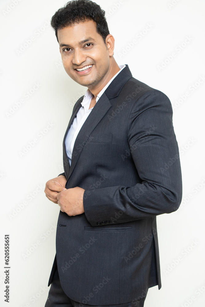 Smiling handsome young indian businessman wearing suit standing posing isolated over white background. Corporate Concept. Smiling handsome young indian businessman wearing suit standing posing isolated over white background. Corporate Concept.