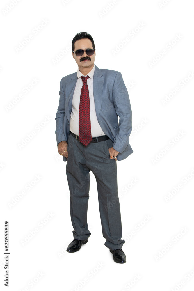 Mature indian businessman wearing suit and sunglasses standing with his hands in pocket isolated over white background. Corporate Concept. Mature indian businessman wearing suit and sunglasses standing with his hands in pocket isolated over white background. Corporate Concept.