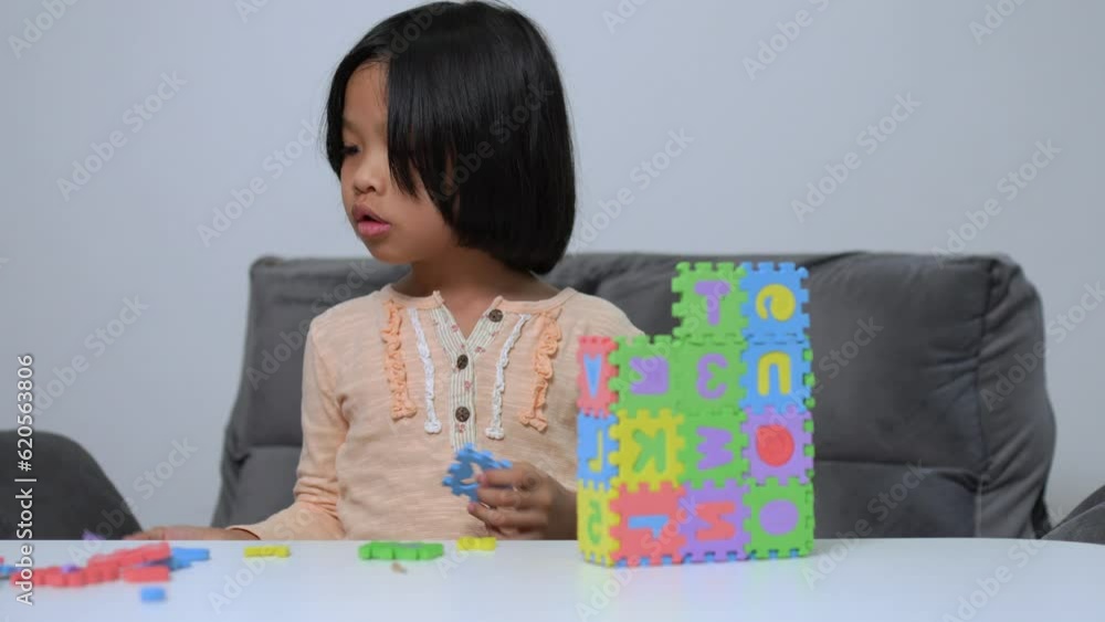 Cute Asian little girl playing with colorful toy ABC jigsaw, Kids play with educational toys at kindergarten or daycare. Creative playing of kid development concept, Toddler kid in nursery. Cute Asian little girl playing with colorful toy ABC jigsaw, Kids play with educational toys at kindergarten or daycare. Creative playing of kid development concept, Toddler kid in nursery.