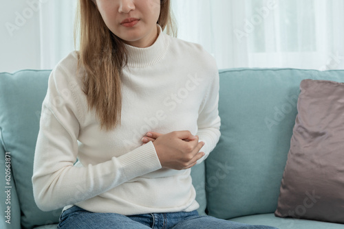 Tableau sur toile hand hold chest with heart attack symptoms, asian woman have chest pain caused by heart disease, leak, dilatation, enlarged coronary heart, press on the chest with a painful expression