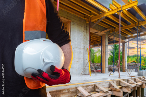 Helmet in builder hand. Whi...