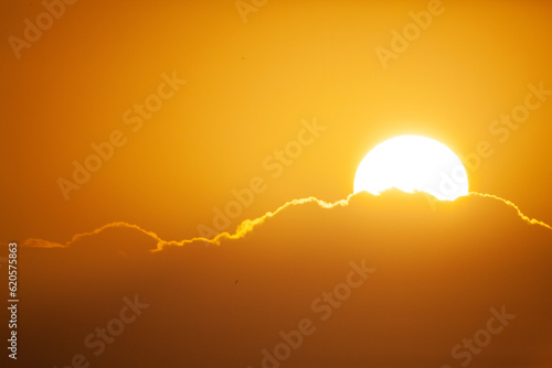 Sun rising over clouds. Orange sky.