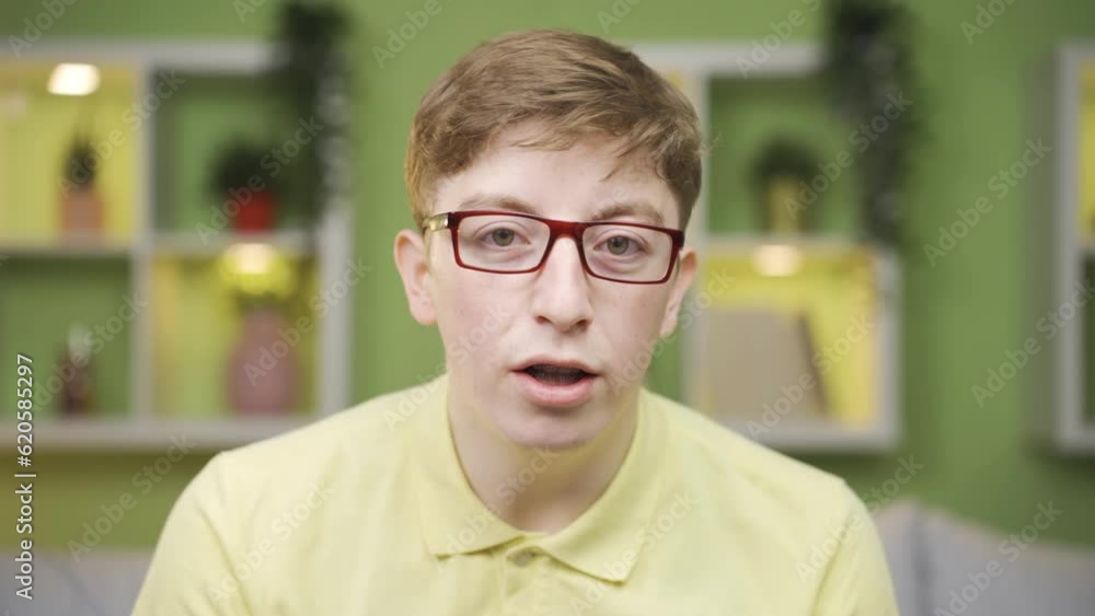 Young man looking at camera at home babbling. Young man looking at camera at home babbling.