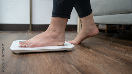 Fat diet and scale feet standing on electronic scales for weight control. Measurement instrument in kilogram for a diet control.