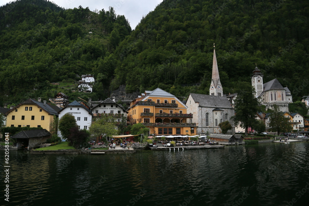 Photo of a serene lakeside town with colorful buildings and boats on the water, Austria