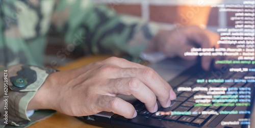 close up soldier man as programmer hand typing command on keyboard laptop to check about software or configuration for military operation system in office room concept 