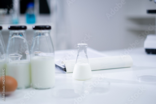 Bottle of a sample milk. Concept of nutrition  lactose  protein  bacteria  fat and glucose laboratory. Dairy milk test. Nutritionist is checking and analyze the quality of factory milk product