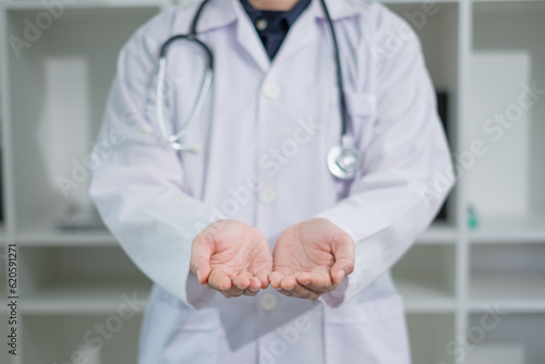 Doctor's empty hand is giving, receiving or offering. Concept of hospital charity advertisement, marketing or commercial. Concept of organ donation. Doctor uniform background or wallpaper.