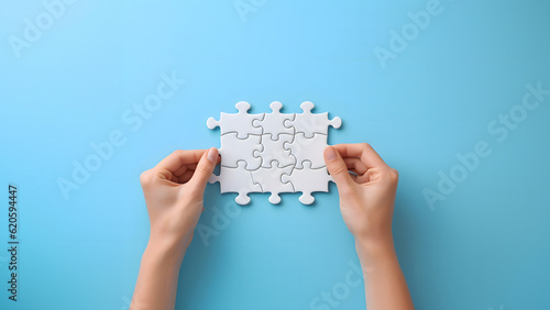 Concept of business,hands holding a jigsaw puzzle on pastel blue background