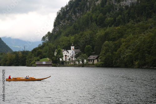 A man peacefully rowing a small boat on a lake, Austria