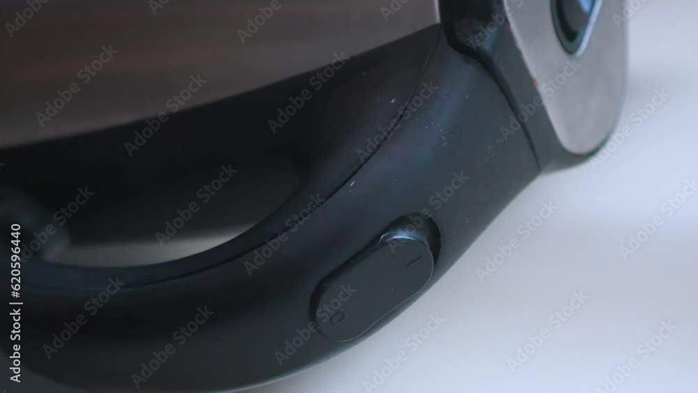 Closeup of electric kettle with boiling water. Power button automatically turns off when water