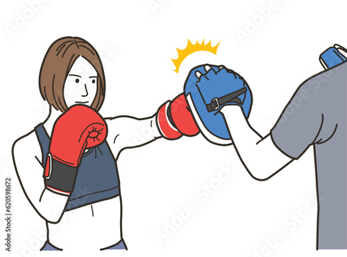 格闘技のパンチをする女性と男性トレーナー 