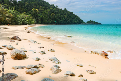 Beautiful tropical beach with white sand, turquoise ocean against blue sky with clouds on sunny summer day. Perfect landscape background for relaxing vacation