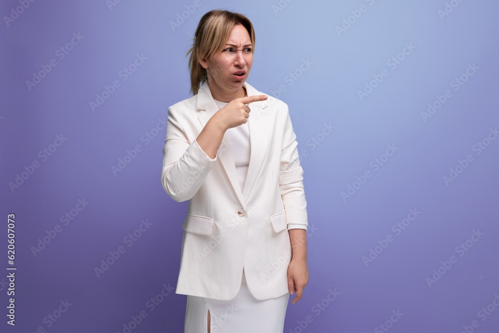 young blond employer woman in a white elegant jacket and skirt looks contemptuously to the side young blond employer woman in a white elegant jacket and skirt looks contemptuously to the side