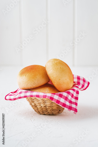 Traditional Colombian bakery made of cheese and flour on a red checkered cloth inside a handmade wicker basket.