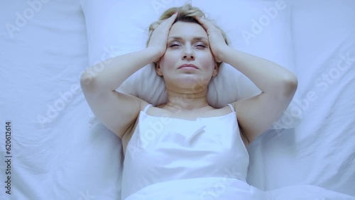 Wallpaper Mural Unhappy annoyed woman massaging head lying on her bed, feeling unpleasant headache, problems with blood pressure, migraine because of menopause starting Torontodigital.ca