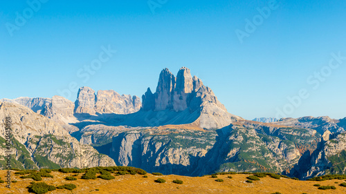 Beautiful magical Three Dolomite peaks at the national park Three Peaks, Tre Cime Drei Zinnen in Autumn colors at blue sky and sunny day, South Tyrol, Italy