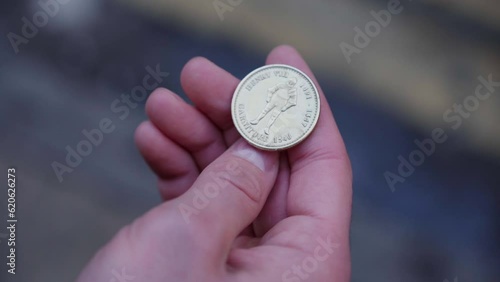 A man's hand with the cheek of his fingers tosses a coin on a black background up to get heads or tails. Concept of coin toss for choice. A coin is tossed up and it flies spinning Hand tossing a coin photo