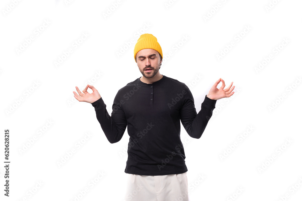 well-groomed authentic brunette male adult in a black sweater is meditating well-groomed authentic brunette male adult in a black sweater is meditating