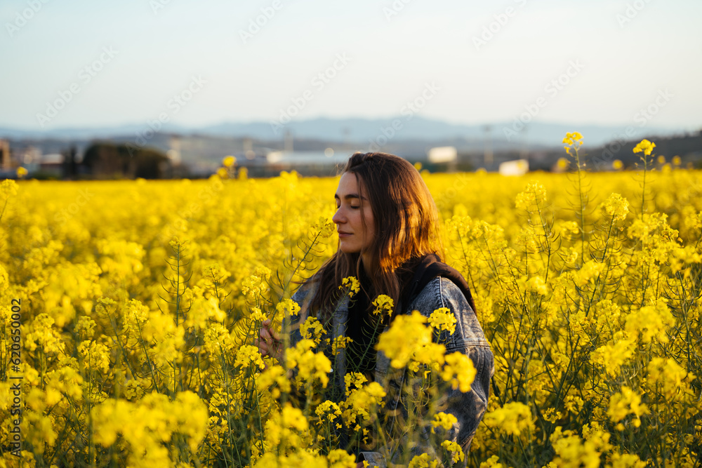 Happy Young woman in flowers field during sunset Happy Young woman in flowers field during sunset