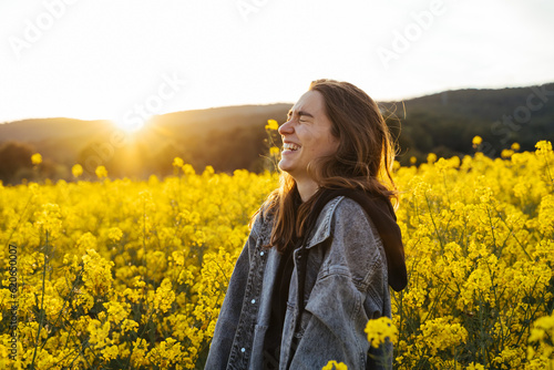 Happy Young woman in flowers field during sunset