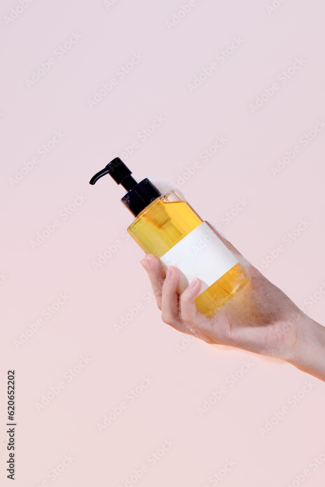 Applying liquid soap. Hands holding bottle with liquid soap Applying liquid soap. Hands holding bottle with liquid soap