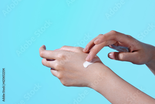 closeup woman applying protective cream on hands. photo