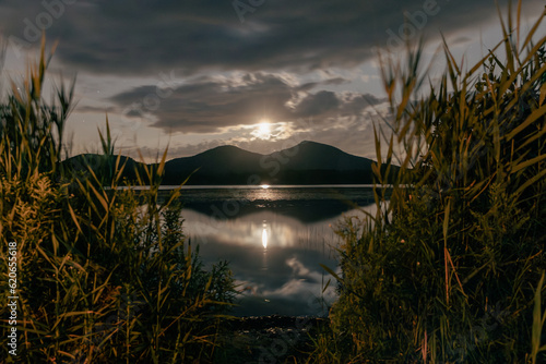 Canvastavla vue de deux sommets de montagnes sur la rive opposée d'un lac calme la nuit avec