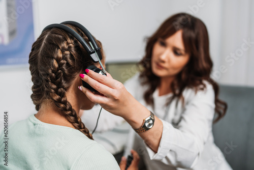 Fotografia Audiologist doing impedance audiometry or diagnosis of hearing impairment