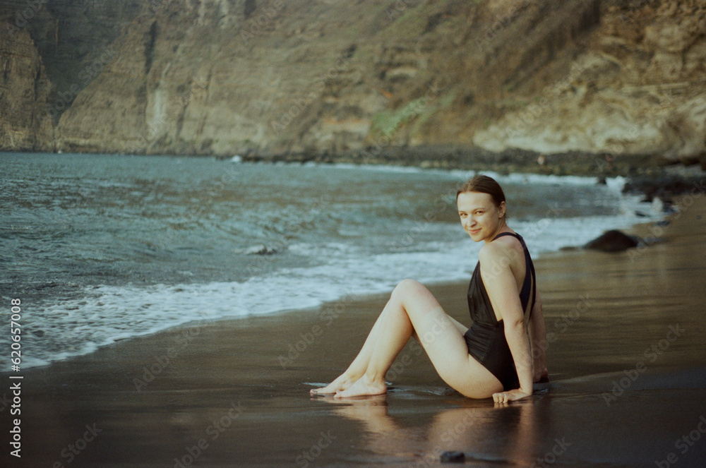 Young Woman Sitting At Hidden Beach In Tenerife Young Woman Sitting At Hidden Beach In Tenerife