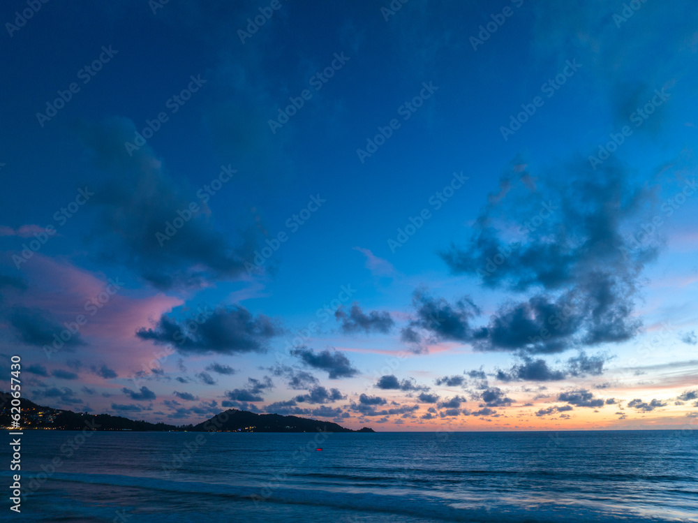 Drones take pictures of the beautiful sky by the beach in stunning sunset..colorful sky in sunset above Patong city at twilight. .Scene of romantic sky sunset background.