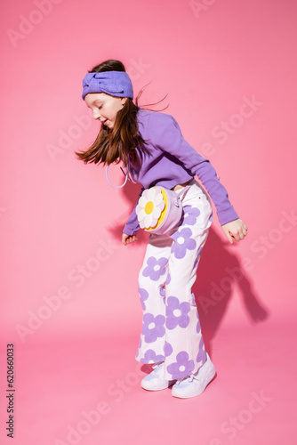 Happy girl jumping on pink background 