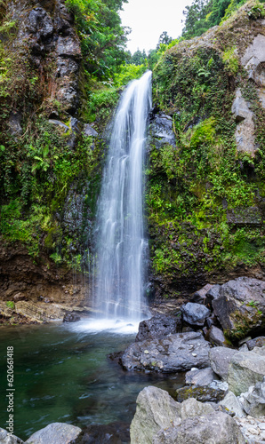 Beautiful waterfall in the middle of the rocks and nature with a defuminated effect in Salto do Cabrito  Azores