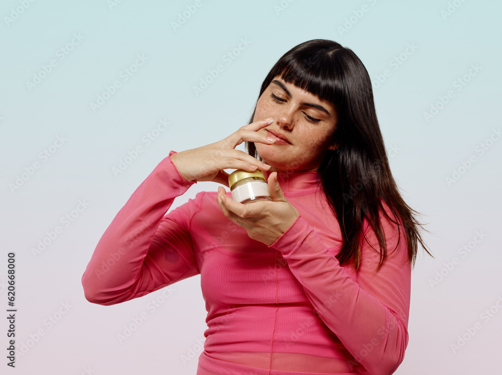 Woman carefully opening skincare product jar Woman carefully opening skincare product jar