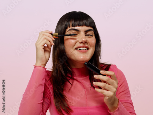 Fun woman in pink applying make up