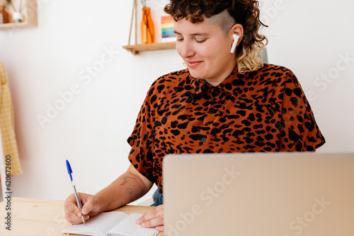 Content non binary person taking notes in notebook photo