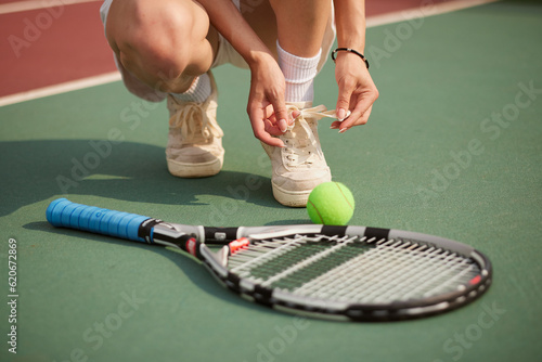 Tennis player woman, shoelace and ready for game, training or exercise sneakers in development, sports or focus. Sport expert, girl athlete and professional shoes with tennis ball, racket and goals