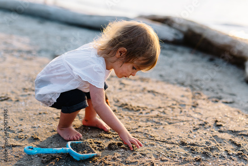 Toddler plays on beach photo