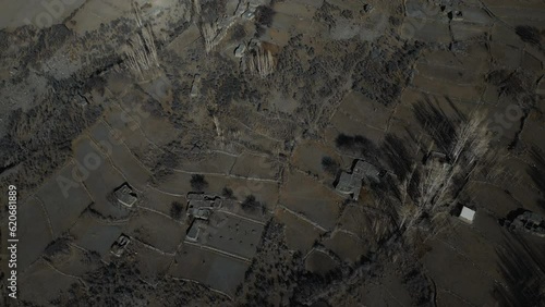 Aerial landscape shot of cultivated land and houses at remote Zarabod Village near Hussain suspension bridge. It is a small agricultural hamlet in Gojal Hunza in Gilgit-Baltistan.Top-down forward shot photo